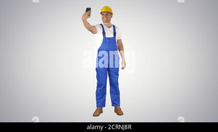 Smiling handsome young builder making selfie with mobile phone o Stock Photo