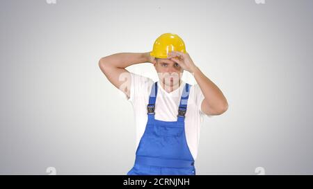 Construction worker walking and putting on hard hat or helmet on Stock Photo