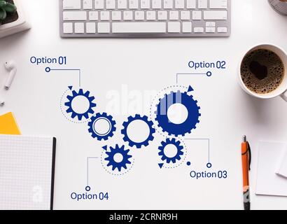 Scheme Of Working Cogwheels Mechanism Over White Office Desk Background Stock Photo