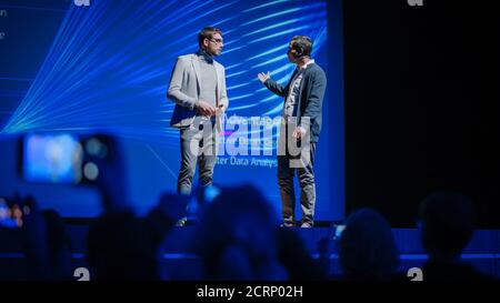 Stage: Startup CEO and Hardware Engineer Present New Product. Speakers Lead Lecture on Business, Science, Technology, Entrepreneurship, Health Stock Photo