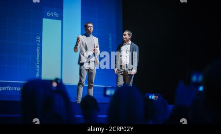 Stage: Startup CEO and Hardware Engineer Present New Product. Speakers Lead Lecture on Business, Science, Technology, Entrepreneurship, Health Stock Photo