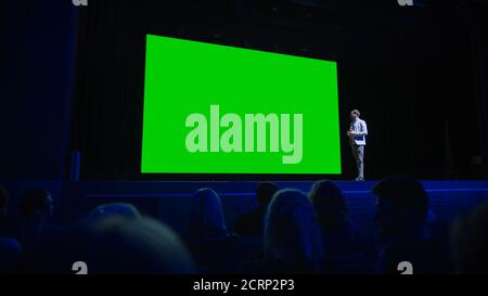 Keynote Speaker Announces New Product to the Audience, Behind Him Movie Theater with Green Screen, Mock-up, Chroma Key. Business Conference Live Event Stock Photo
