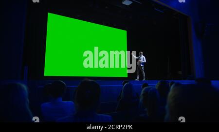 Keynote Speaker Announces New Product to the Audience, Behind Him Movie Theater with Green Screen, Mock-up, Chroma Key. Business Conference Live Event Stock Photo