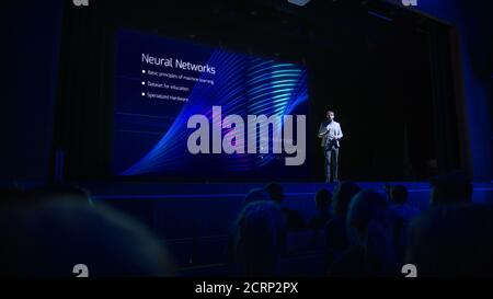 Computer Science Startup Conference: On Stage Speaker Does Presentation of New Product, Talks about Neural Networks, Shows New AI, Big Data and Stock Photo