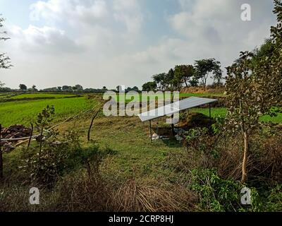 Solar panel plate installed on agriculture green field area. Stock Photo