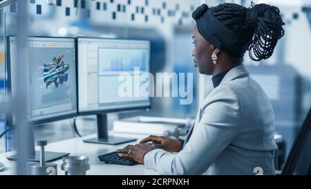 Beautiful Female Engineer Working on Personal Computer in the High-Tech Industrial Factory, She Uses CAD Software Designing 3D Turbine. Modern High Stock Photo