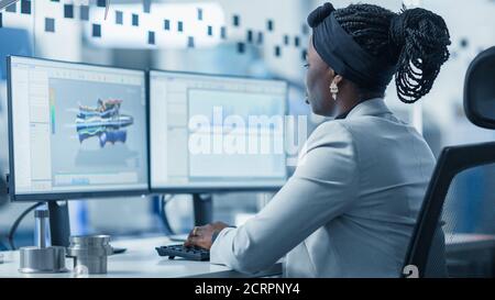 Beautiful Female Engineer Working on Personal Computer in the High-Tech Industrial Factory, She Uses CAD Software Designing 3D Turbine. Modern High Stock Photo