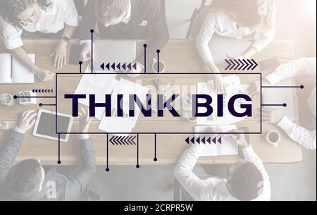 Think big text over team having business meeting in office Stock Photo