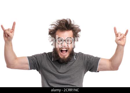 Crazy Bearded happy Man with funny Haircut in Eyeglasses making rock and roll gesture. Cheerful and silly guy, isolated on white background. Stock Photo