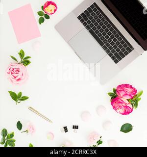 Laptop with roses flowers and copy space on white background. Flat lay. Top view. Stock Photo