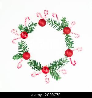 Merry Christmas composition of branches and red decoration with candy cane on white background. Flat lay, top view Stock Photo