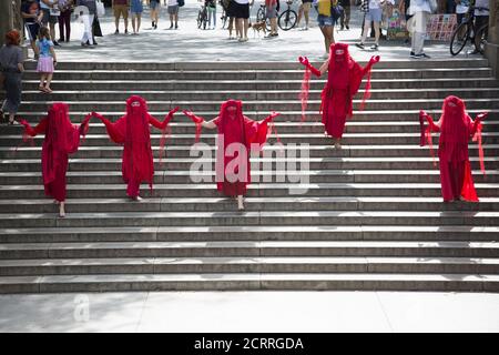 The Red Rebels, Brigade, who are a branch of Extinction Rebellion, dressed in bright red to signify the blood of species that have died as a result of climate change, as well as those that will die in the future demonstrate and march at Bethesda Fountain in Central Park organized by 'Extinction Rebellion' to bring attention to the immediate need for system change in the US and around the world to combat  the climate crisis that is now being experienced world wide in the form of wildfires, hurricanes, droughts and floods along with air and water pollution at an unprecedented scale. Stock Photo