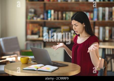 Confused Asian Woman Having Problems With Laptop While Working Remotely In Cafe Stock Photo