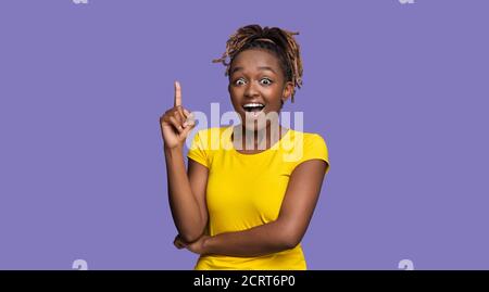 Inspired black female pointing finger up, got idea Stock Photo