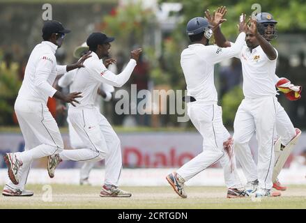 Sri Lanka's Rangana Herath (R) celebrates with his teammates Dimuth Karunaratne (2nd R) , captain Angelo Mathews (L) and Tharindu Kaushal after taking the wicket of India's Wriddhiman Saha (not pictured) during the fourth day of their first test cricket match in Galle August 15, 2015. REUTERS/Dinuka Liyanawatte