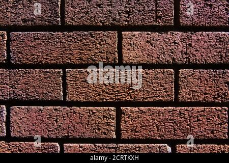 1 - Horizontal red brick wall background texture. Monochromatic appearance and dark shadows between the bricks. Stock Photo