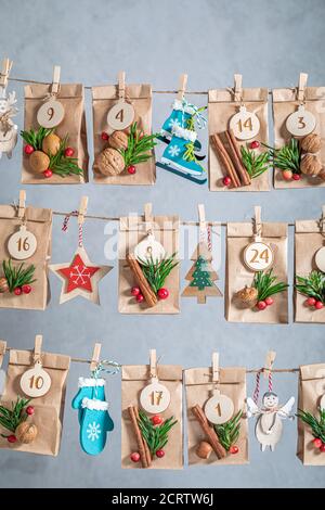 Handmade Advent Calendar for Christmas made of paper and stringon the background of gray wall Stock Photo