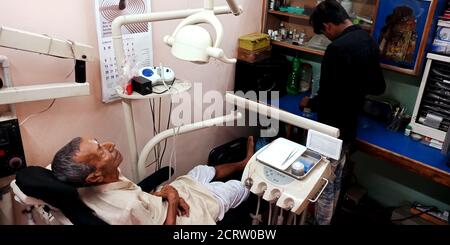 DISTRICT KATNI, INDIA - SEPTEMBER 29, 2019: An indian village old patient lying on dentist chair for oral infection testing at dental clinic in city h Stock Photo