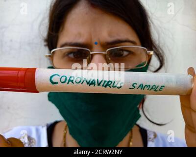 DISTRICT KATNI, INDIA - MAY 14, 2020: An asian female presented on hand coronavirus kit sample wearing pink face mask with specs. Stock Photo