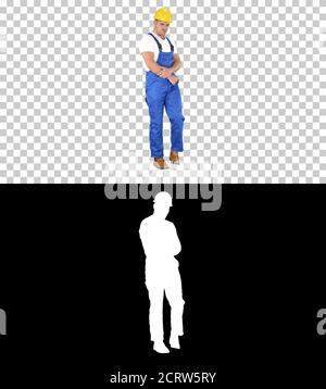Workman with helmet walking in a funny way and laughing, Alpha C Stock Photo