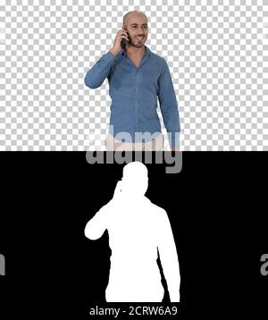 Young arab man walking and talking on the phone and smile, Alpha Stock Photo