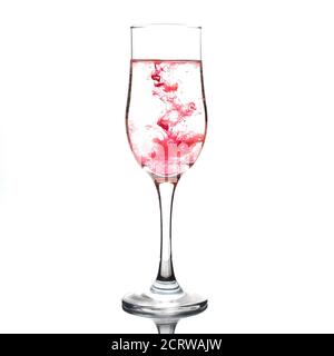Food coloring diffuse in water inside wine glass area for slogan or advertising text message on white background Stock Photo