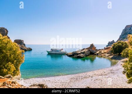 Saria, Karpathos, Greece - October 2, 2019: Palatia, Turquoise beach on Saria Island with parked Kapetan Nikolas tour boat Stock Photo