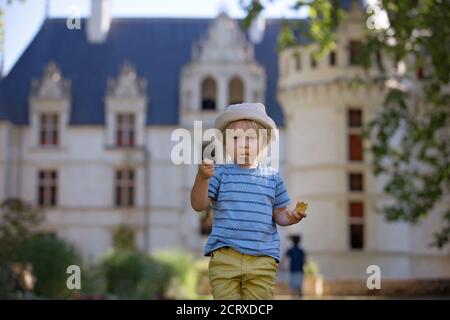 Cute child, toddler boy, eating ice cream in a park on a summer sunny day Stock Photo