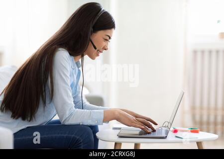 Remote Jobs For Students. Asian Lady Working As Call-Center Operator At Home Stock Photo