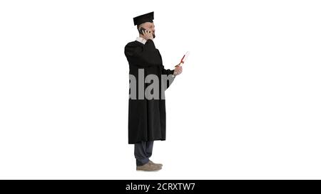 Happy graduated young man in cap and gown talking with parent on Stock Photo