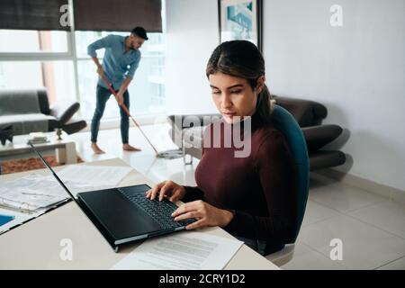 Business Woman Working At Home And Man Doing Chores Stock Photo