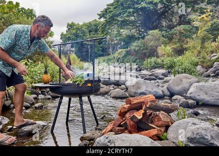 Barbecue Over Wood Fired Grill Near Stream by Cavan Images
