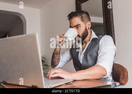 Handsome man dressed as executive  drinking coffee and working Stock Photo