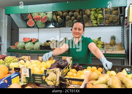a shopkeeper is in front of her fruit shop looking at the camera. working concept Stock Photo