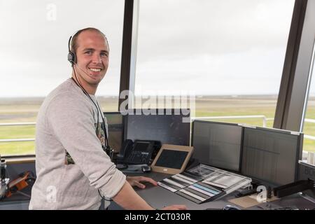 Happy man in headset smiling and looking at camera during work in airport Stock Photo