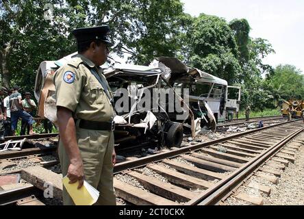 A Sri Lankan policeman stands guard at the wreckage of a passenger bus which collided with an express train in Polgahawela, Sri Lanka.  A Sri Lankan policeman stands guard at the wreckage of a passenger bus which collided with an express train in Polgahawela, central Sri Lanka April 27, 2005. Thirty-seven bus passengers were killed and dozens injured when a train rammed into the crowded vehicle at a level crossing in Sri Lanka on Wednesday, crushing it and setting it ablaze, officials said. REUTERS/Anuruddha Lokuhapuarachchi