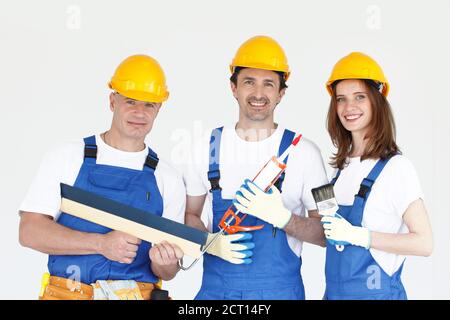 Portrait of renovation workers in blue and yellow uniform with their tools on white Stock Photo