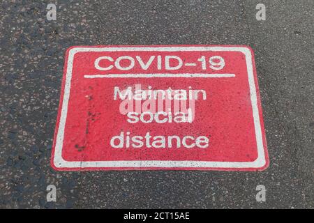 Physical distancing sign on pavement Stock Photo