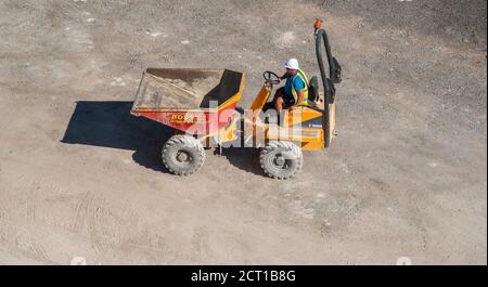 Ramsgate, Kent, England, UK. 2020.  Overview of a male worker driving a dumper truck working on a building site in the UK. Stock Photo
