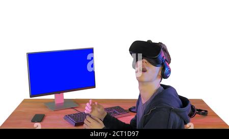 Young gamer in virtual reality headset sitting at table on white Stock Photo