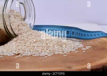 Pile of rice from a jar and measure tape. Stock Photo