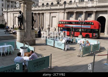 Diners and drinkers sit within street barriers where Fortnum & Mason have set up an outdoor restaurant and bar in front of the Royal Exchange at Bank, in the City of London, during the Coronavirus pandemic, on 9th September 2020, in London, England. Stock Photo