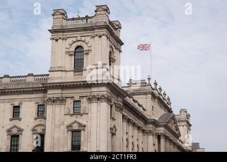 As a police officer watches a small protest in Parliament Square, the Union Jack flies over the Treasury in Whitehall, the location for many British government buildings in Westminster, on 16th September 2020, in London, England. Stock Photo