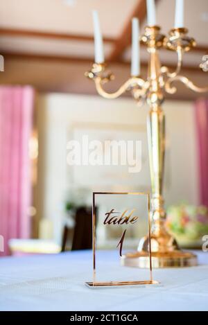 Candelabra candlesticks are golden in color, decorating the table of guests at the wedding. Room table for guests to disembark. Wedding decor and deco Stock Photo