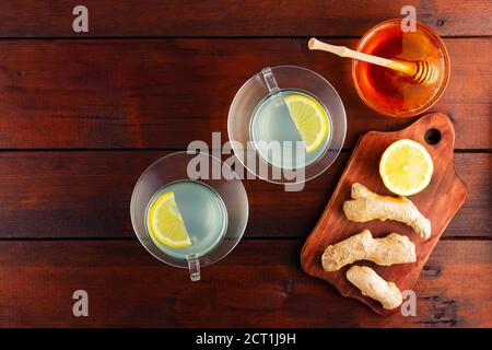 Ginger tea with lemon. Two cups of ginger tea with lemon and honey on wooden background. Top view Stock Photo