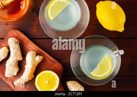 Ginger tea with lemon. Two cups of ginger tea with lemon and honey on wooden background. Top view Stock Photo