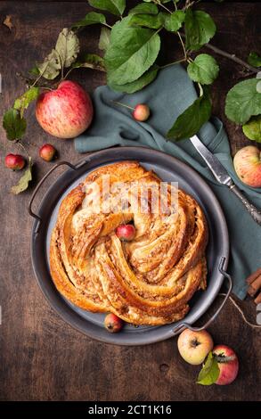 top view of fresh homemade cinnamon roll on plate on marble surface ...