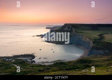 Worth Matravers, Dorset, UK.  20th September 2020.  UK Weather.  The sky glows orange at sunset above Chapmans Pool and the cliffs of Houns Tout on the Jurassic Coast near Worth Matravers in Dorset during the last few days of the autumn heatwave before the weather is forecast to cool down.  Picture Credit: Graham Hunt/Ģ����ý Live News Stock Photo