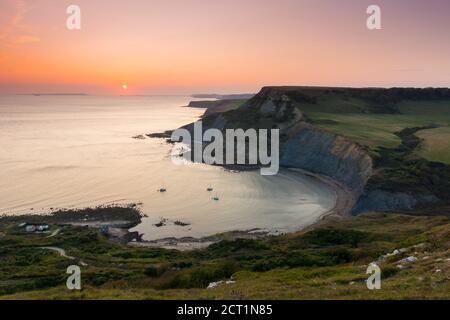 Worth Matravers, Dorset, UK.  20th September 2020.  UK Weather.  The sky glows orange at sunset above Chapmans Pool and the cliffs of Houns Tout on the Jurassic Coast near Worth Matravers in Dorset during the last few days of the autumn heatwave before the weather is forecast to cool down.  Picture Credit: Graham Hunt/Ģ����ý Live News Stock Photo