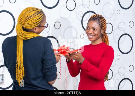 young black lady giving a friend a gift Stock Photo